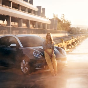 Frau lehnt an der Motorhaube eines GWM ORA 03