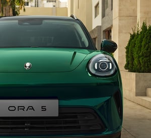 GWM ORA 5 SUV, Detailaufnahme Frontpartie mit rundem LED-Scheinwerfer und Modellschriftzug